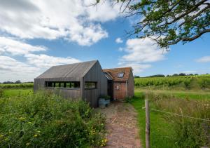 a barn conversion with a metal roof and a brick building at The Lookers Legacy in Stone