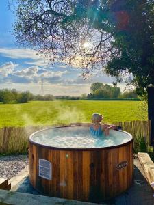 a woman in a hot tub in a field at Bailey's Hideaway in Portadown