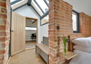 a bedroom with a brick wall and a bed and a window at The Lookers Legacy in Stone