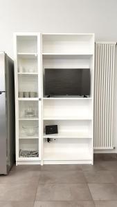 a white cabinet with a tv and a refrigerator at Appartamento Tagliamento 13 - Affitti Brevi Italia in Riccione