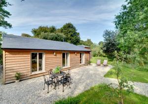 a cabin with a table and chairs in front of it at The Hideaway in Eastry