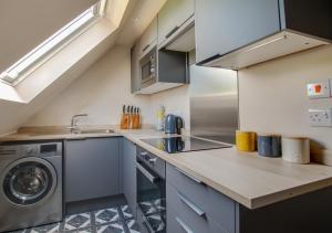 a kitchen with a sink and a washing machine at The Honey Pot in Lyminge