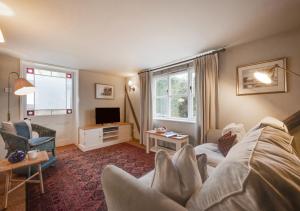 a living room with a couch and a tv at The Little House in Rolvenden