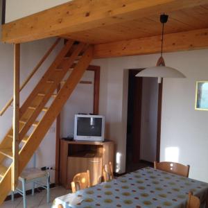 a room with a table with a television and a staircase at Biogarden in Zelarino