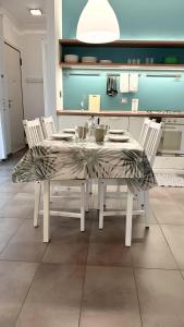 stół jadalny z białymi krzesłami i ścierką stołową w obiekcie Appartamento Tagliamento 13 - Affitti Brevi Italia w mieście Riccione
