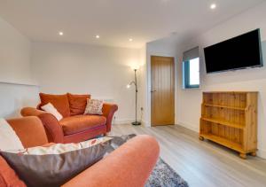 uma sala de estar com 2 sofás e uma televisão de ecrã plano em The Pump House em Hernehill