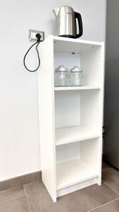a white cabinet with three jars and a kettle on it at Appartamento Tagliamento 13 - Affitti Brevi Italia in Riccione