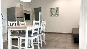 Appartamento Tagliamento 13 - Affitti Brevi Italia في ريتشيوني: غرفة طعام مع طاولة وأربعة كراسي