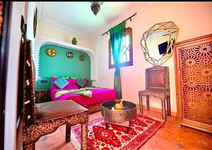 sala de estar con cama y silla en Riad Maison Aicha, en Marrakech