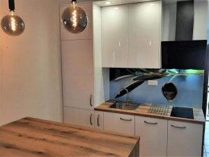 a kitchen with white cabinets and a sink and a table at Apartments Olive i Lavender in Mandre +17 photos