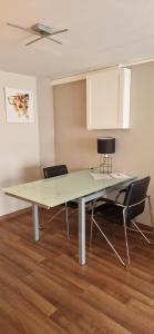un tavolo da pranzo con 2 sedie e un soffitto di Studio chaleureux avec parking gratuit a Vandœuvre-lès-Nancy
