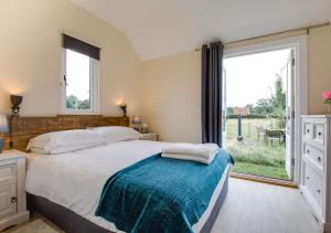 a bedroom with a large bed and a large window at The Warren in Biddenden
