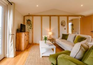 a living room with a couch and a table at Treetops at Bewl Water in Wadhurst