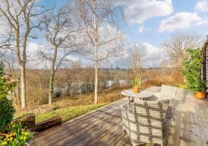 a patio with a table and chairs on a wooden deck at Treetops at Bewl Water in Wadhurst