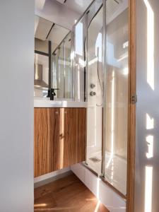 baño con ducha y armario de madera. en Casa Flotante Sanxenxo, en Sanxenxo