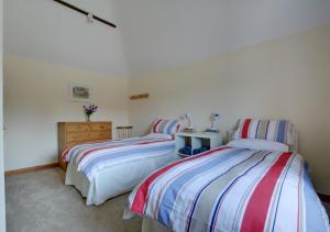 a bedroom with two beds and a dresser at Waders in Beckley