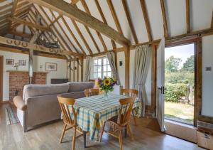 a living room with a table with chairs and a couch at Wagon Lodge at Forstal Farm in Tenterden