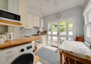 a kitchen with a table and a clock on the wall at Umballa in Herne Bay