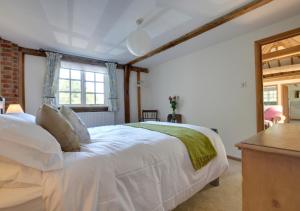 a bedroom with a white bed and a window at Wagon Lodge at Forstal Farm in Tenterden