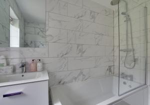 a bathroom with a shower and a tub and a sink at Valley View in Upper Hardres