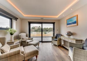 a living room with couches and chairs and windows at Vause at Sea in Kingsdown