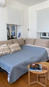 um quarto com uma cama, um sofá e uma mesa em Naias Aegina, Sea-front apartment 95 sqm em Egina