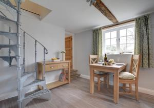a dining room with a table and a desk at Well Cottage in Barham