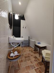 ein Badezimmer mit einem Waschbecken, einem Tisch und einem WC in der Unterkunft Suite dans un château dans le Haut Anjou in Pouancé