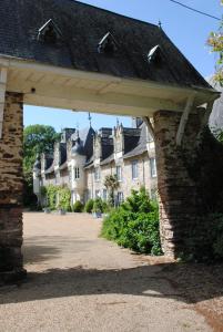 ein Torbogen vor einem großen Gebäude in der Unterkunft Suite dans un château dans le Haut Anjou in Pouancé
