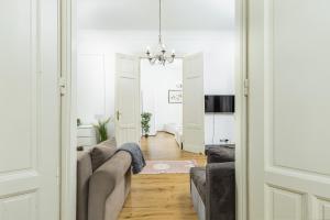sala de estar con sofá y sala de estar con lámpara de araña. en Real Apartments Wesselényi, en Budapest