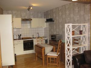 eine Küche mit einem Tisch und Stühlen sowie eine Küche mit weißen Schränken in der Unterkunft Ferienwohnung Anger 18 in Bad Frankenhausen