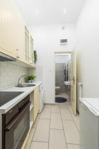 cocina blanca con lavabo y aseo en Real Apartments Wesselényi, en Budapest