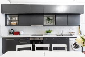 a kitchen with black cabinets and white appliances at Real Apartments Wesselényi in Budapest