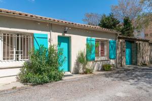 een huis met turquoise deuren en ramen bij Oasis centre charme in Montpellier