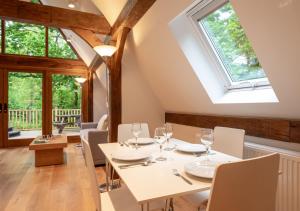 a dining room with a table and chairs and windows at Waterside Lodge in Bodiam