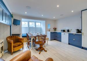 a kitchen with a table and chairs and blue cabinets at West Ascent in Hollington