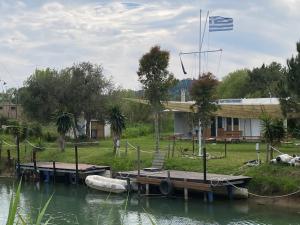 a house with a dock and a boat on the water at CASA JOHN in Alepou