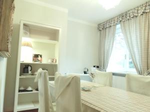 Un comedor con mesa y sillas y una ventana. en Villa Olivia, en Bérgamo