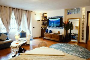 uma sala de estar com um sofá e uma televisão em Lake experience! em Marone