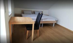 Zimmer mit einem Tisch und einem Bett mit einem gmaxwell gmaxwell gmaxwell Bett in der Unterkunft Ferienwohnungen Weishaupt, Pfingstweider Str. 30 in Meckenbeuren