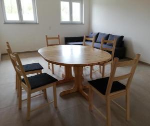 einen Holztisch und Stühle im Wohnzimmer in der Unterkunft Ferienwohnungen Weishaupt, Pfingstweider Str. 30 in Meckenbeuren