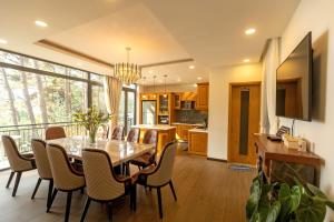 comedor y cocina con mesa y sillas en Luxury 5 bedroom villa - Tuyen lam lake view en Xuan An