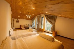 two beds in a room with wooden ceilings at Luxury 5 bedroom villa - Tuyen lam lake view in Xuan An