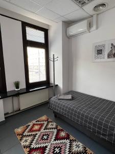 Habitación con cama, alfombra y ventana en Aleja "Solidarności", en Varsovia