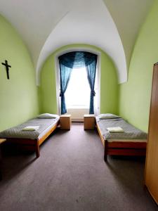 a room with two beds and a window at Diecezjalny Dom Formacyjny in Nysa