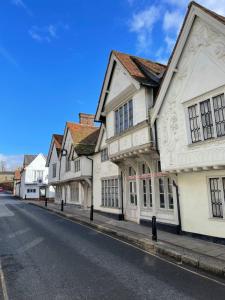 a row of white buildings on a city street at Brand New! Stunning, Stylish, Cosy Apartment in Centre of Saffron Walden in Saffron Walden