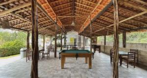 a pool table in a pavilion with tables and chairs at Chalé Descanso in Barreirinhas