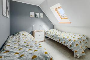 a bedroom with two beds and a night stand at Colibri 2 met parking in Nieuwpoort