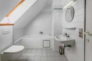 a white bathroom with a sink and a toilet at Colibri 2 met parking in Nieuwpoort