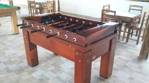 a large wooden foosball table sitting on a floor at Chalé Descanso in Barreirinhas